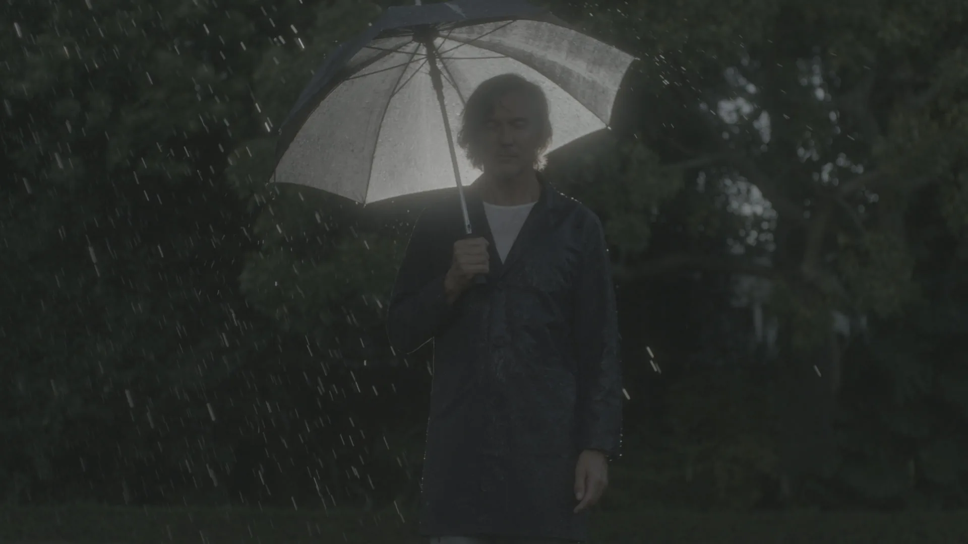 Three clips going from flat camera footage to a Filmly look: a man with an umbrella in the rain, police cars on a snowy road, and a skier on a sunny mountain